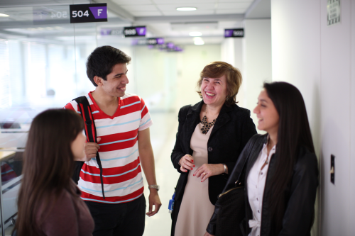Profesora ríe con sus estudiantes